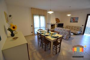 uma cozinha e sala de estar com mesa e cadeiras em Villa Aurora em Ilha Albarella