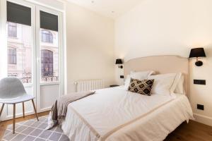 a bedroom with a bed and a chair and a window at LUXURY GUGGENHEIM MUSEUM in Bilbao