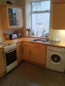 a kitchen with a sink and a washing machine at Rose of Sharon Retreat in Largs