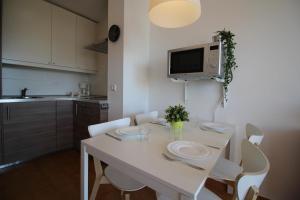 エンプリアブラバにあるBasic Comfort Apartment Gran Reserva 0103のキッチン(白いテーブル、白い椅子付)