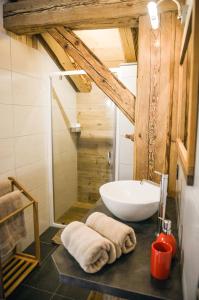 W łazience znajduje się biała umywalka i prysznic. w obiekcie La grange d'Aldaré Chambres d'hôtes w mieście Combloux
