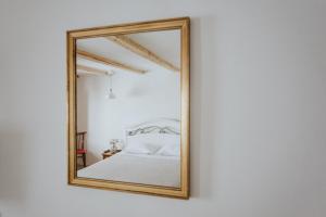 - un miroir reflétant un lit dans une chambre blanche dans l'établissement Casa Milina, à Šibenik