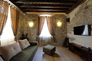 uma sala de estar com um sofá e uma parede de pedra em Desiderata Studio Apartment em Split