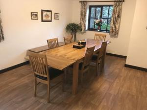 uma sala de jantar com uma mesa de madeira e cadeiras em Linhay -Farm Cottage em Sidmouth