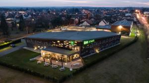 un grande edificio con un cartello sopra la notte di ibis Styles Le Mans Sud Mulsanne a Mulsanne