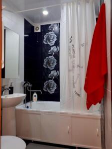 baño con cortina de ducha blanca y lavamanos en Димитрова 80/1 Апартаменты в Темиртау, en Temirtaū