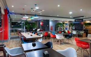 a restaurant with tables and chairs in a cafeteria at ibis Sao Jose in São José