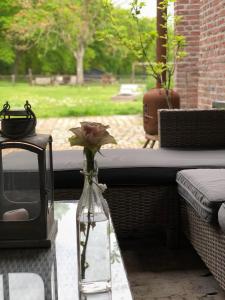 een vaas met een roos erin zittend op een tafel bij B&B Landgoed Bergerven in Horn