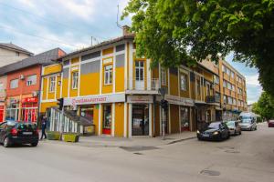 a street with cars parked in front of a yellow building at Ilidza Blue Nest in Sarajevo