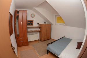 Una pequeña habitación abuhardillada con una cama y un armario. en Pupa Apartment 120 m2 Center Sarajevo, en Sarajevo