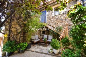 un edificio de piedra con un patio con sillas y plantas en Casa Rural Refugio de Heda, en San Bartolomé de Tormes