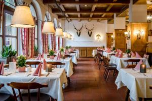 une rangée de tables dans un restaurant avec des nappes blanches dans l'établissement Hotel IMLAUER & Bräu, à Salzbourg