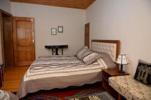 a bedroom with a bed and a table and a piano at Guest House Taunus in Berat