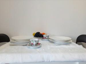 un tavolo con piatti e tazze e frutta di Anni a Belgrado