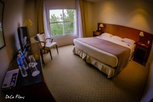 Una cama o camas en una habitación de Elegance Hotel Tandil