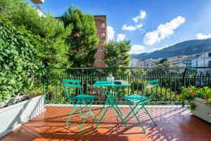 un patio con 2 sillas y una mesa en el balcón en Casa Evelina Sorrento, en Sorrento