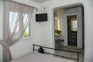 a bedroom with a bed and a mirror at Porto Manolis in Agios Ioannis Tinos