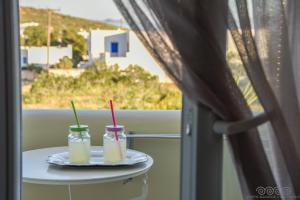 dos bebidas en una mesa frente a una ventana en Porto Manolis, en Agios Ioannis