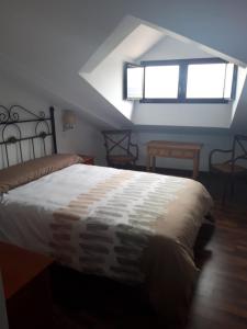 a bedroom with a large bed in a attic at Pensión STOP in El Cubillo de Uceda