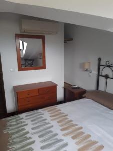 a bedroom with a bed and a dresser and a mirror at Pensión STOP in El Cubillo de Uceda