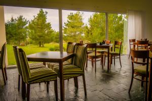a restaurant with tables and chairs and a large window at Elegance Hotel Tandil in Tandil