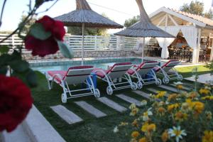 a row of chairs next to a swimming pool at Morisi Konak Butik Otel in Alacati