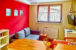 a living room with a table and a red wall at Ferienwohnung Mäder in Schaafheim