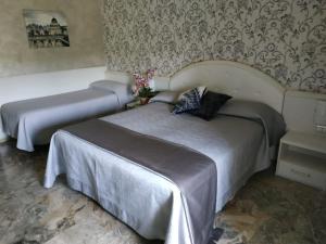 a bedroom with two beds and a wall at Hotel Orazia in Rome