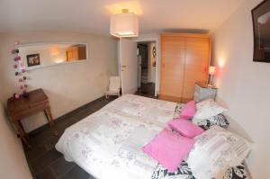 1 dormitorio con 1 cama grande con almohadas rosas en Gîte Perle d'Ô, en Profondeville