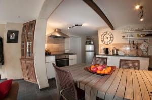 uma cozinha com uma mesa de madeira e uma taça de fruta em Gîte Perle d'Ô em Profondeville