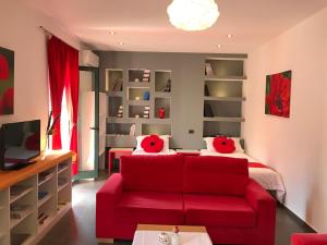 a living room with a red couch and a bed at Hotel Rimini Tirana in Tirana