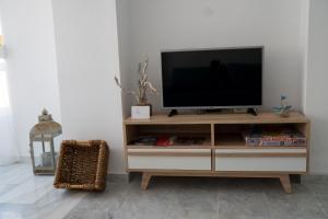 a television on a wooden entertainment center in a living room at Apartamento Punta de Torrox in Torrox