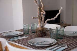 a table with plates and glasses and a tree on it at Apartamento Punta de Torrox in Torrox
