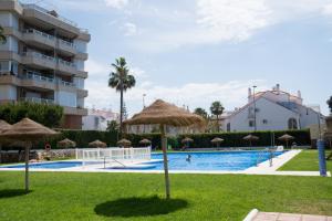 a swimming pool with umbrellas and a resort at Apartamento Punta de Torrox in Torrox