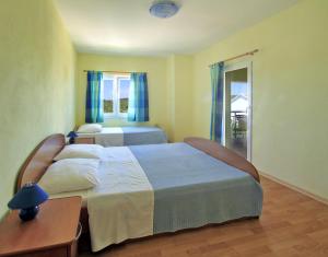 a bedroom with two beds with blue curtains and a table at Apartments Đuričić in Lovište