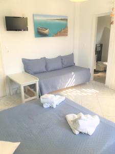 a living room with two beds and a couch at Pension Sofia Amorgos-Katapola in Katapola