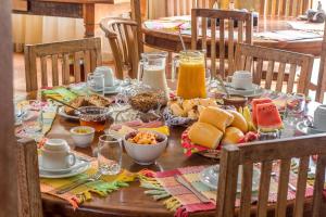 una mesa de madera con comida y bebidas. en Pousada Neuza Barbosa, en Tiradentes