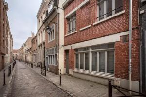an empty street in an alley between buildings at 3 Chambres au cœur du vieux Lille in Lille