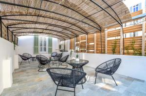 eine Terrasse mit Stühlen und Tischen unter einer Decke in der Unterkunft Résidence Montaigne - Luxurious - 350m Palais - LRA Cannes in Cannes