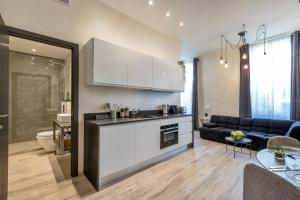 eine Küche und ein Wohnzimmer mit Sofa und Tisch in der Unterkunft Résidence Montaigne - Luxurious - 350m Palais - LRA Cannes in Cannes