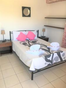 a bedroom with a large bed with pink pillows at Pension Sofia Amorgos-Katapola in Katapola