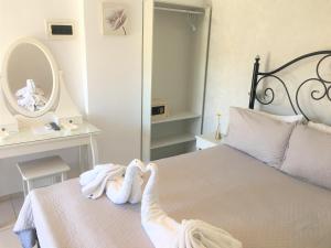 a bedroom with two towels on a bed with a mirror at Pension Sofia Amorgos-Katapola in Katapola
