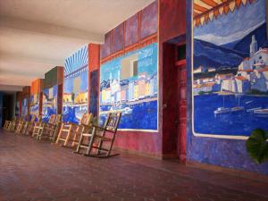 Eine Stuhlreihe in einem Raum mit Gemälden an den Wänden in der Unterkunft Hotel Hacienda Bugambilias La Paz in La Paz + 69 Fotos