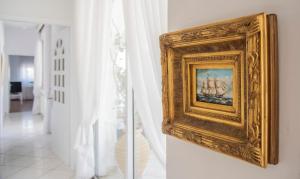 a gold picture hanging on a wall in a room at Casa Bianca - Good Living in Preveza
