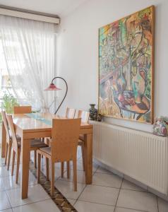 a dining room with a table and chairs and a painting at Casa Bianca - Good Living in Preveza