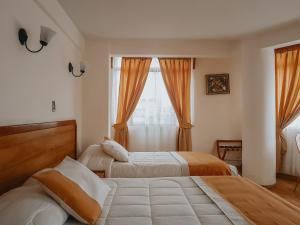 a hotel room with two beds and a window at Hotel MST Colonial in Iquique