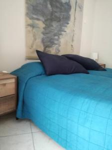 a blue and white bed with a blue blanket on top of it at Hotel Marko in Loutraki