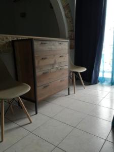 a wooden dresser with two chairs in a room at Hotel Marko in Loutraki