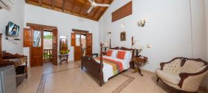 a bedroom with a bed and a desk and a chair at Casa Del Curato in Cartagena de Indias