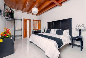 a hotel room with a bed and a tv at Casa Del Curato in Cartagena de Indias